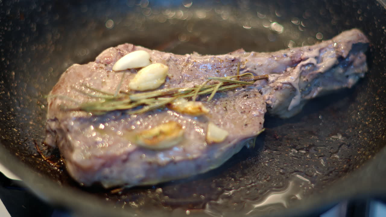 Juicy ribeye steak meat beef being prepared with rosemary and garlic