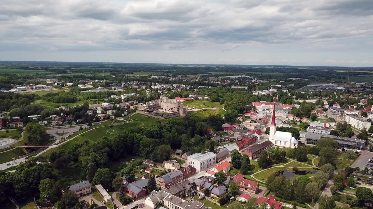4K Luftfoto: Dramatisk kontrast mellom Rakvere bystadion med historiske Vallimägi slott og Treenighetskirken, Estland 2025