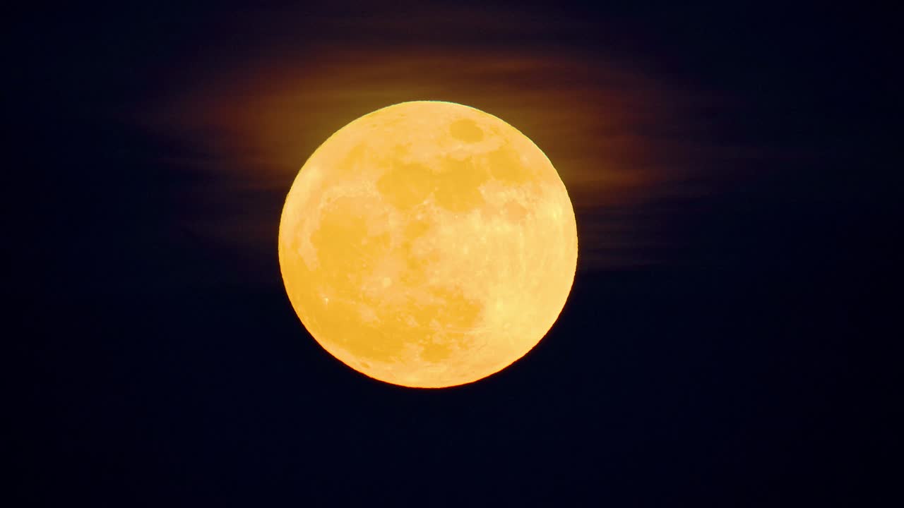 Rara superlua azul cheia com tons de amarelo em degradê laranja e neblina, céu preto escuro