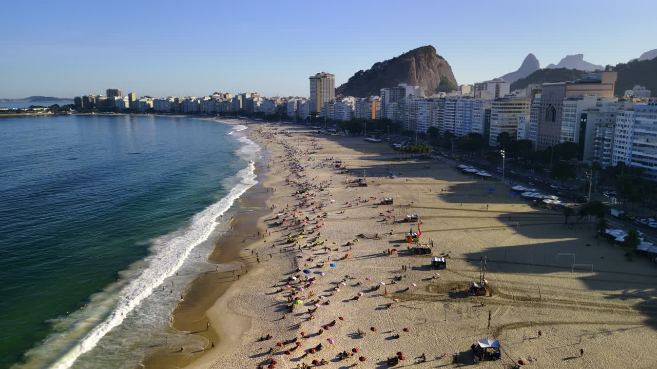 aérea: personas tomando el sol en la playa de copacabana, una tarde soleada en río de janeiro, brasil
