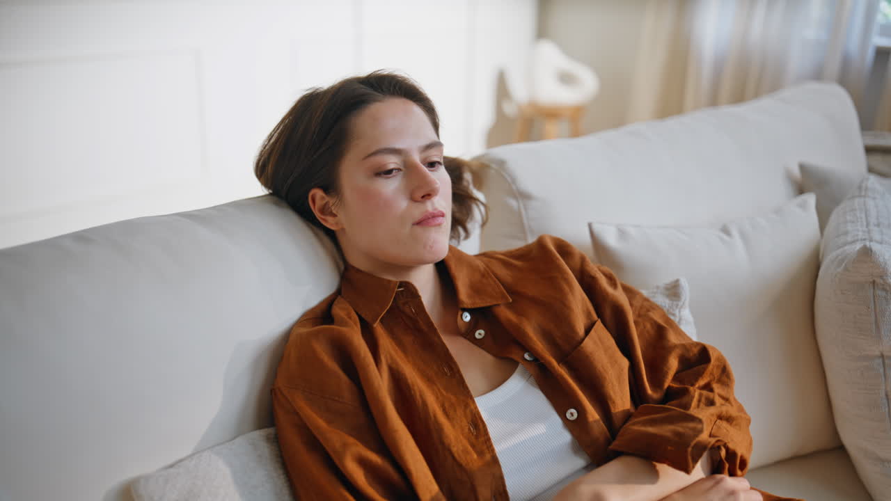 Girl resting comfortable sofa feeling tired closeup. Serious woman falling couch