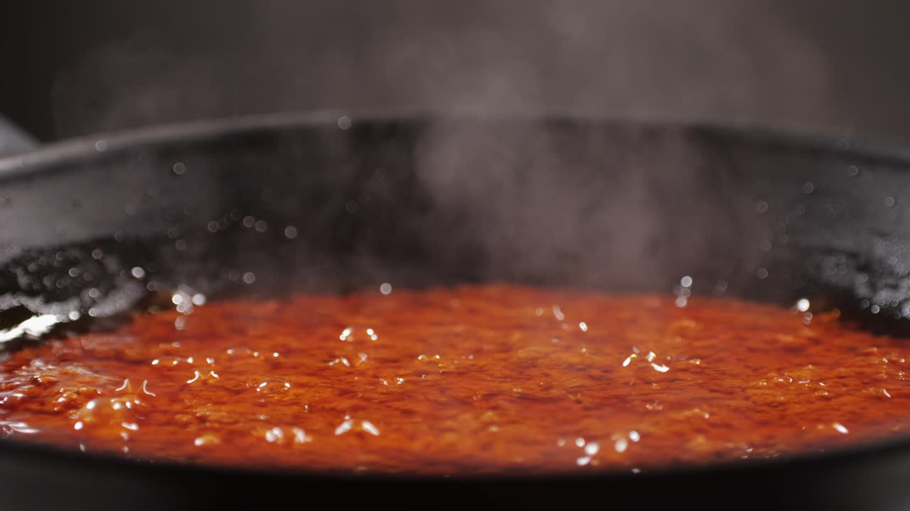 Cooking tomato sauce close-up. Classic homemade Italian tomato sauce for pasta and pizza in the pan. Chef cooking traditional Italian food. High quality 4k footage