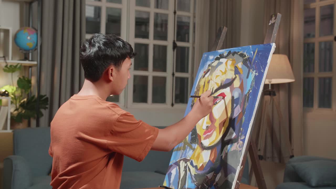 Medium Shot Side View Of An Asian Artist Man Holding Paintbrush Mixed Colour And Painting A Girl'S Ear On The Canvas