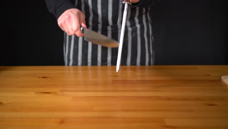 slow motion of a man chef using various techniques to sharpen a knife with his hands, using a professional knife and a diamond sharpening steel