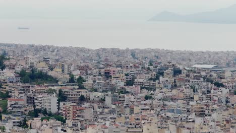 Luftaufnahmen-Eines-Stimmungsvollen,-Bewölkten-Tages-Vom-Stadtzentrum-Von-Athen,-Griechenland,-Mit-Meerblick-Im-Hintergrund