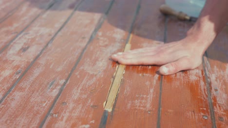 fitting wooden spline insert into wooden boat roof planking rubbing hand across