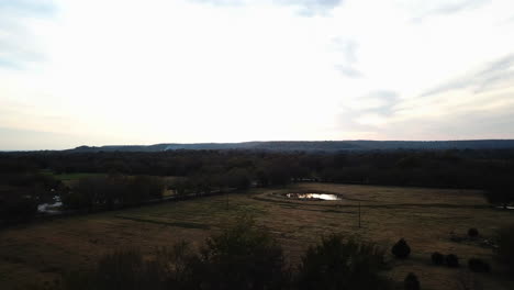 aerial dolly revealing a small pond and a dense forest