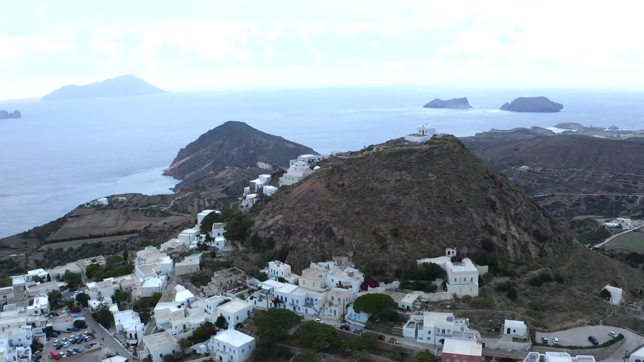 그리스 밀로스 섬의 언덕에 있는 흰색 건물을 둘러싸고 있는 플라카 마을의 매끄러운 영화 영상 4k