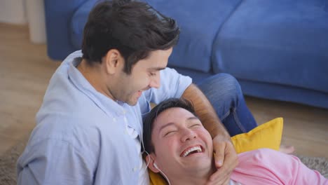 happy gay couple relaxing together at home