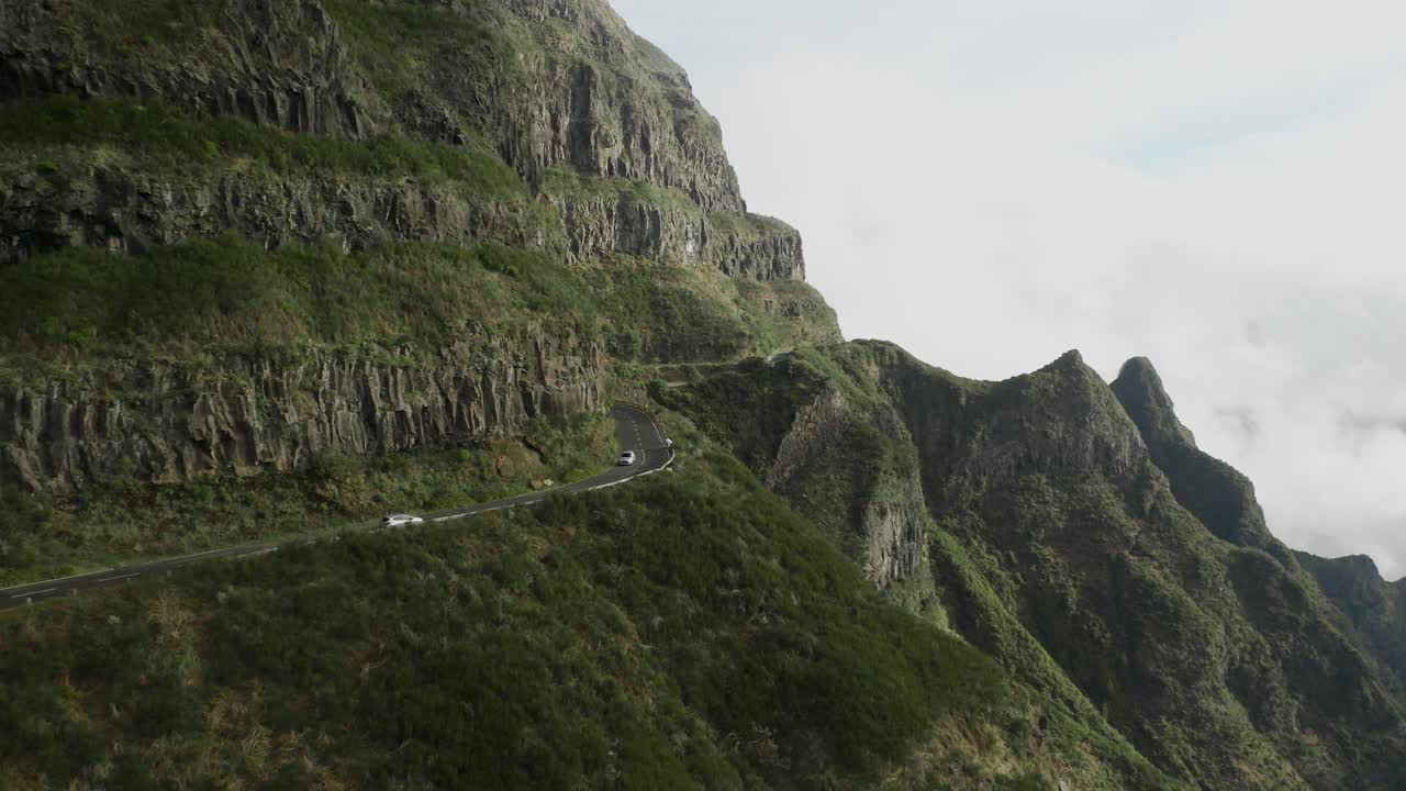 Due auto che viaggiano in direzione opposta e si incrociano su una strada di montagna tortuosa a Madeira, vista aerea.