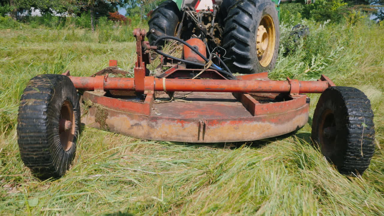 잔디를 깎는 장치의 후면 보기 그는 트랙터에 의해 당겨집니다.