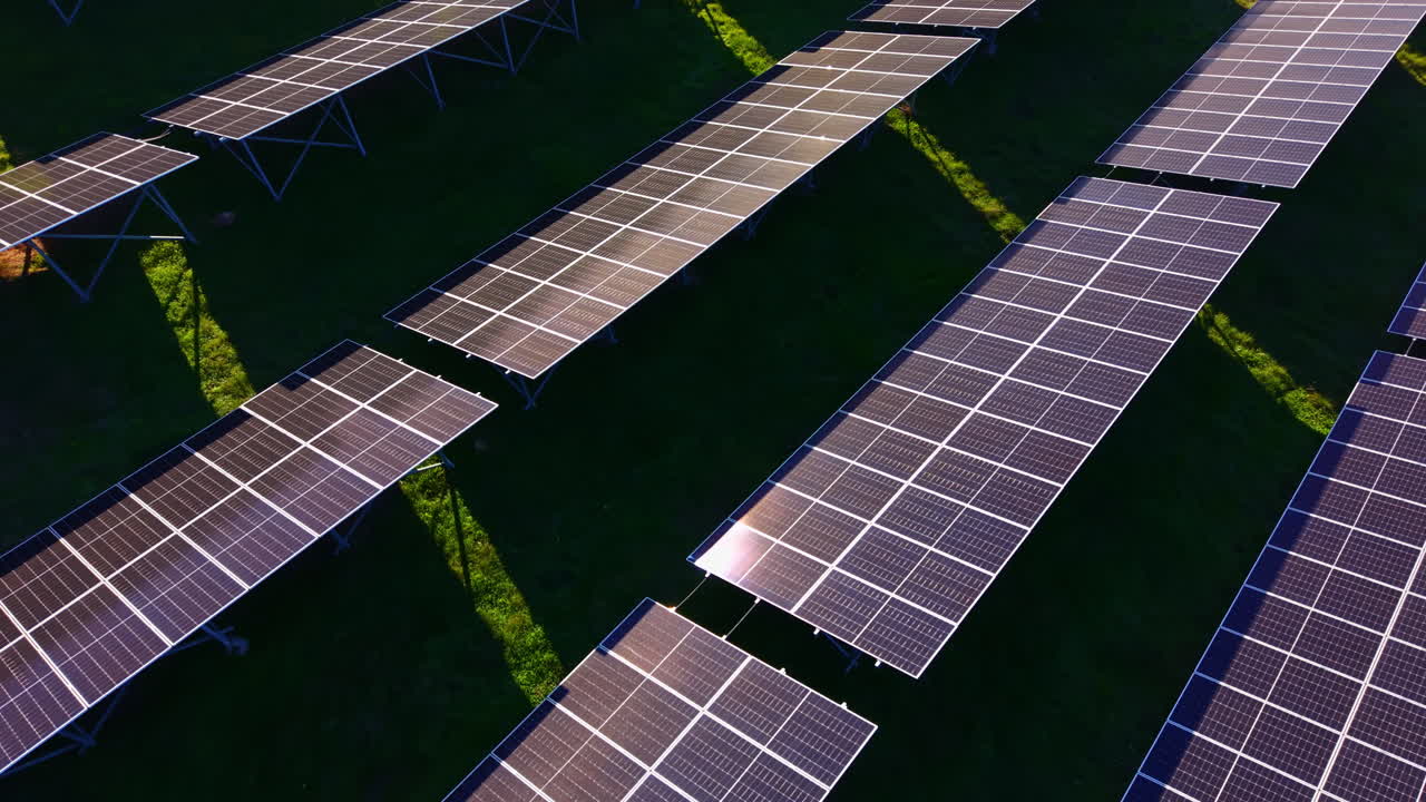Pannelli solari luccicanti sotto il sole di mezzogiorno, che mostrano la tecnologia per l'energia rinnovabile in un paesaggio verde