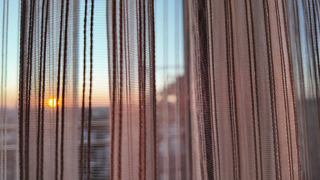 Golden Hour Light Shining Through Sheer Window Curtains