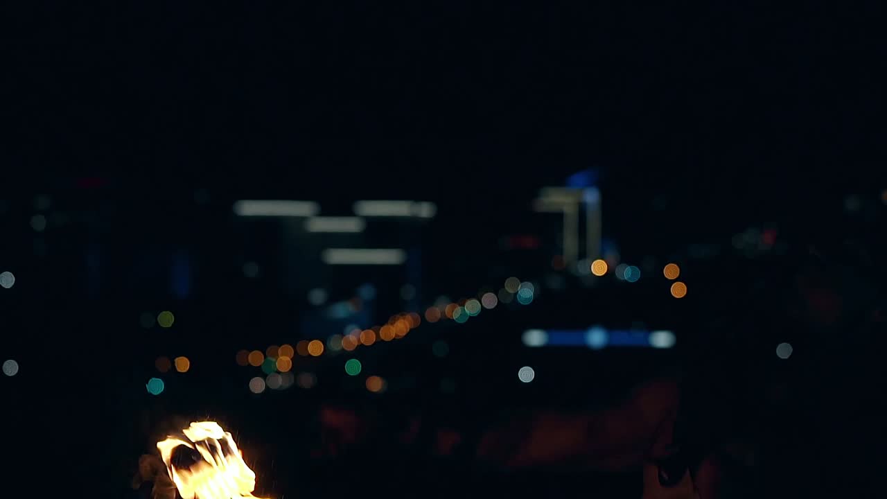 un joven hombre rubio exhala una gran corriente de fuego dos veces haciendo bolas de fuego en cámara lenta en primer plano