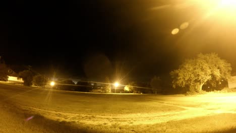 lapso nocturno - las nubes se desplazan sobre una ciudad mirando desde la carretera frente a un edificio antiguo