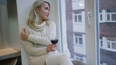 Charming-woman-with-wine-sitting-near-window