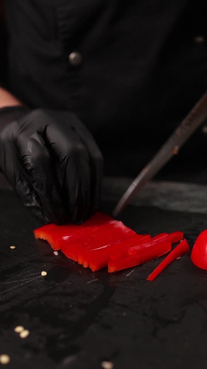 el chef cortando pimientos rojos