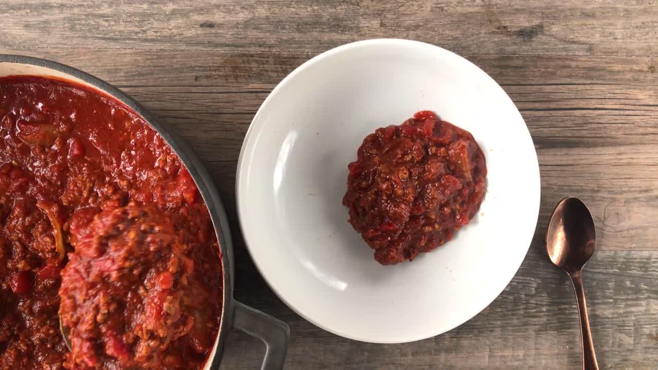 cucharear una olla de chili sin frijoles en la vista superior del tazón