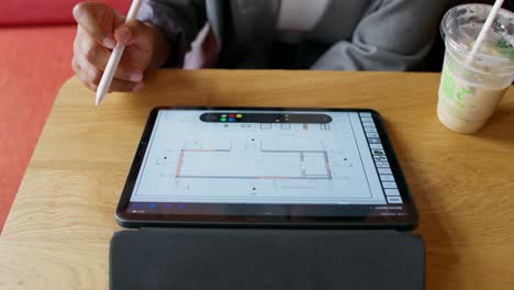 persona que trabaja en un plano de piso digital en una cafetería