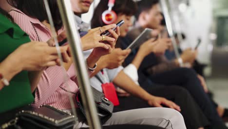 jóvenes usando teléfonos móviles en trenes subterráneos públicos