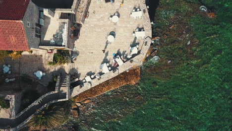 drone volando de la familia cenando en un restaurante en la muralla de la ciudad vieja en budva, montenegro