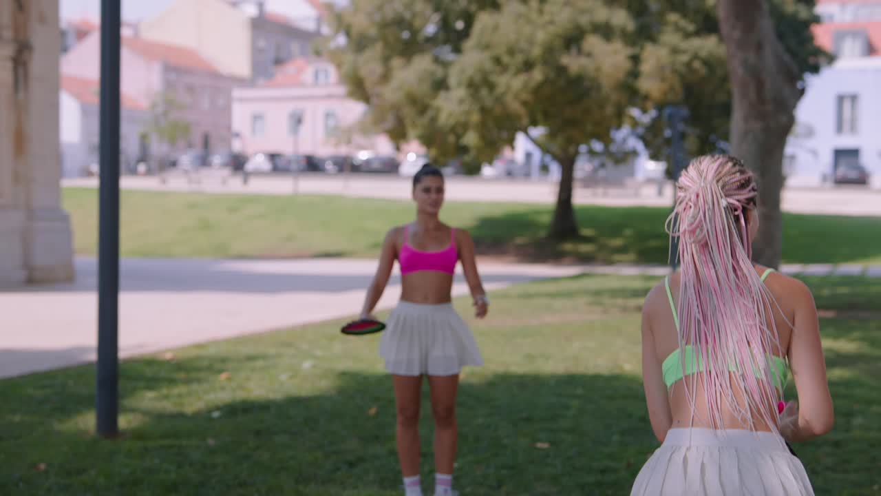 Two young women playing a game outdoors in a park
