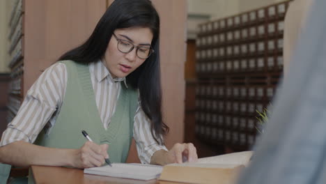 mujer estudiando en una biblioteca