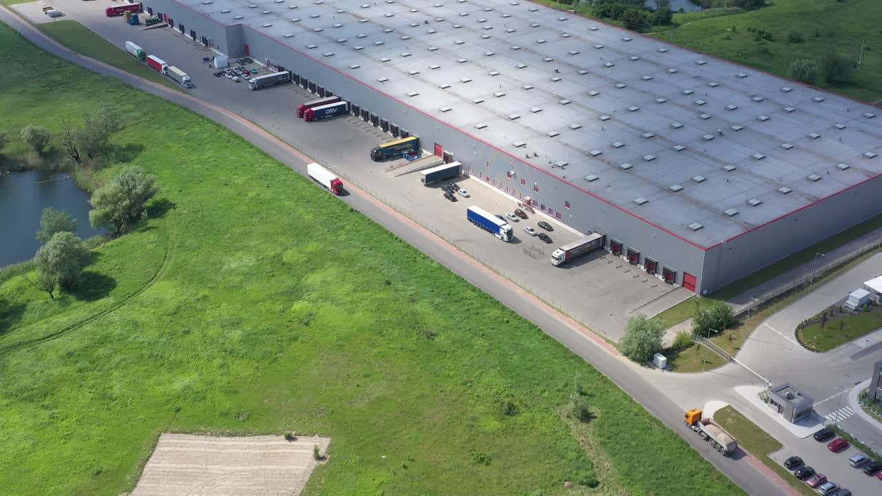 toma aérea de un camión con un semirremolque adjunto que sale del complejo de almacenes