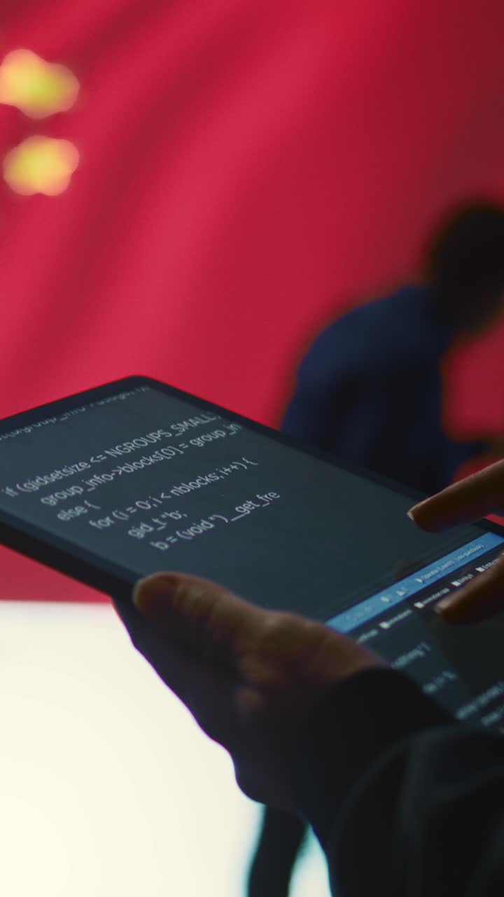 Hand Holding Tablet Displaying Code Against Chinese Flag