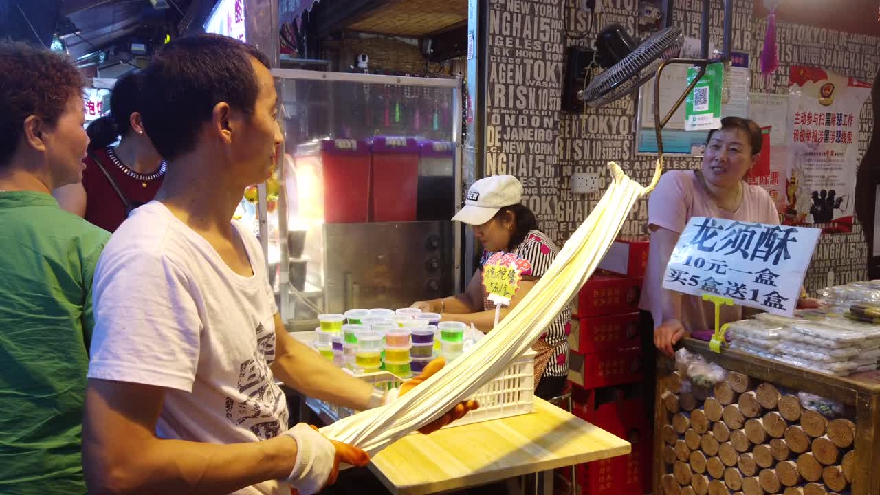 Xian, China -  July 2019 : Older man preparing dough for noodles and pasta in a traditional way on the street in the Muslim Quarter
