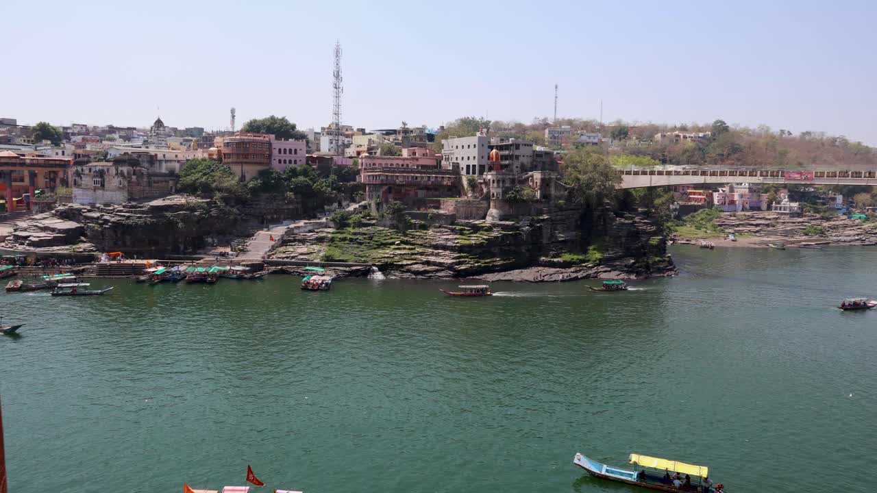 ciudad situada en la orilla del río sagrado con barcos de ferry turísticos por la mañana el video se toma en omkareshwar khandwa madhya pradesh india el 10 de marzo de 2024
