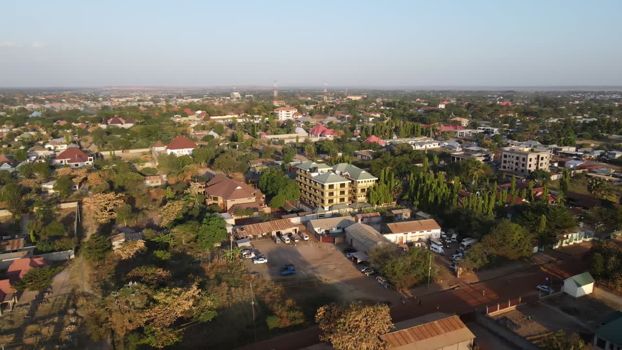 A stunning parallax drone shot of a 5-star hotel in Africa at sunset. Captures the luxurious architecture, golden skies, and serene surroundings.