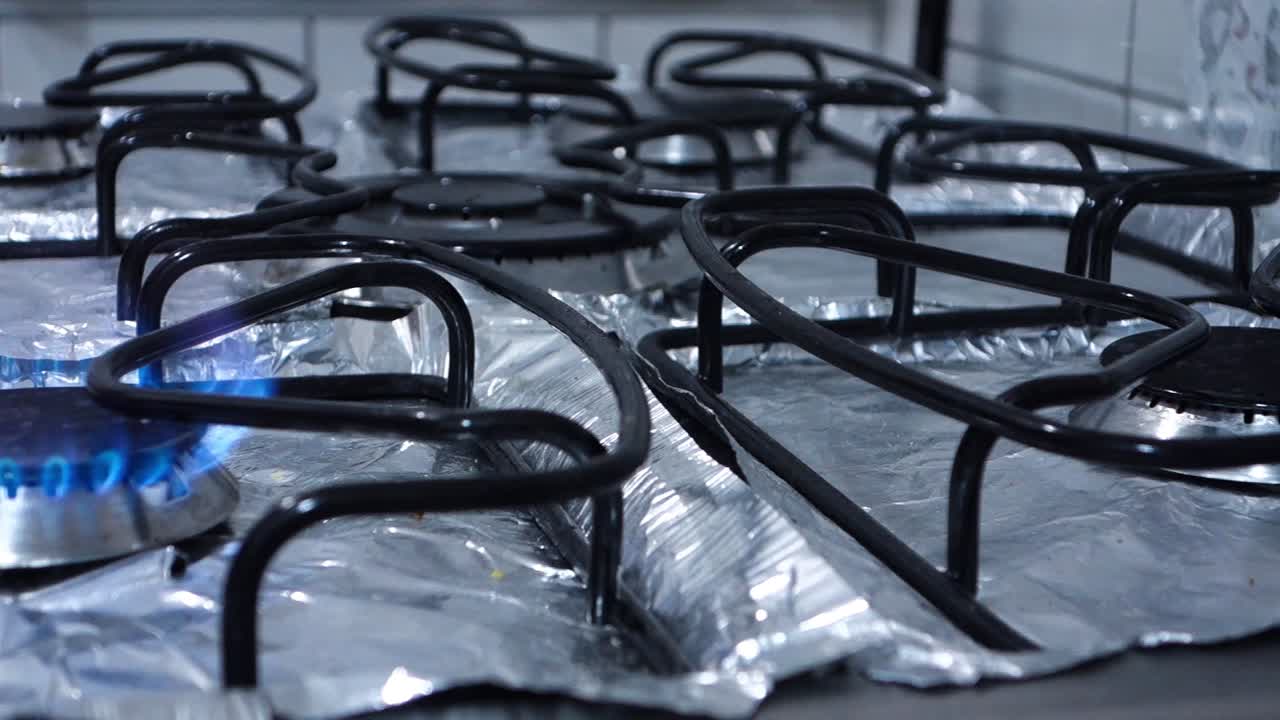 파란 불꽃이 차례대로 꺼지는 가정용 주방 버너, 클로즈업