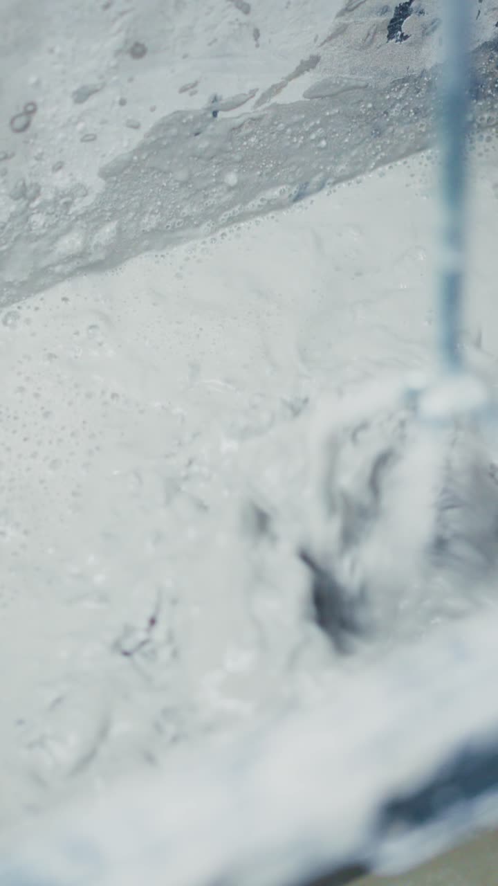 Mixing Creamy Substance: A Close-Up View of Batching and Blending in a Container, Showcasing the Dynamic Movement and Texture of the Mixture
