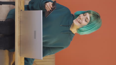 Vertical-video-of-Young-woman-laughing-at-phone-message.