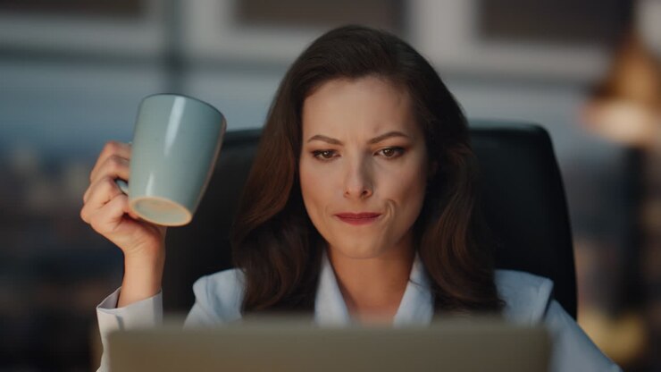 Business woman drinking coffee evening workplace closeup. Lady looking laptop