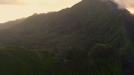 4k drone shot of light rays coming through mountain ridge in oahu hawaii
