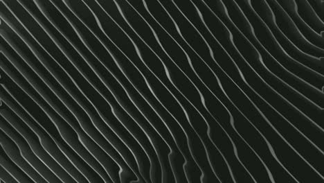 abstract gray white smooth wavy lines pattern flowing on black surface background - closeup shot