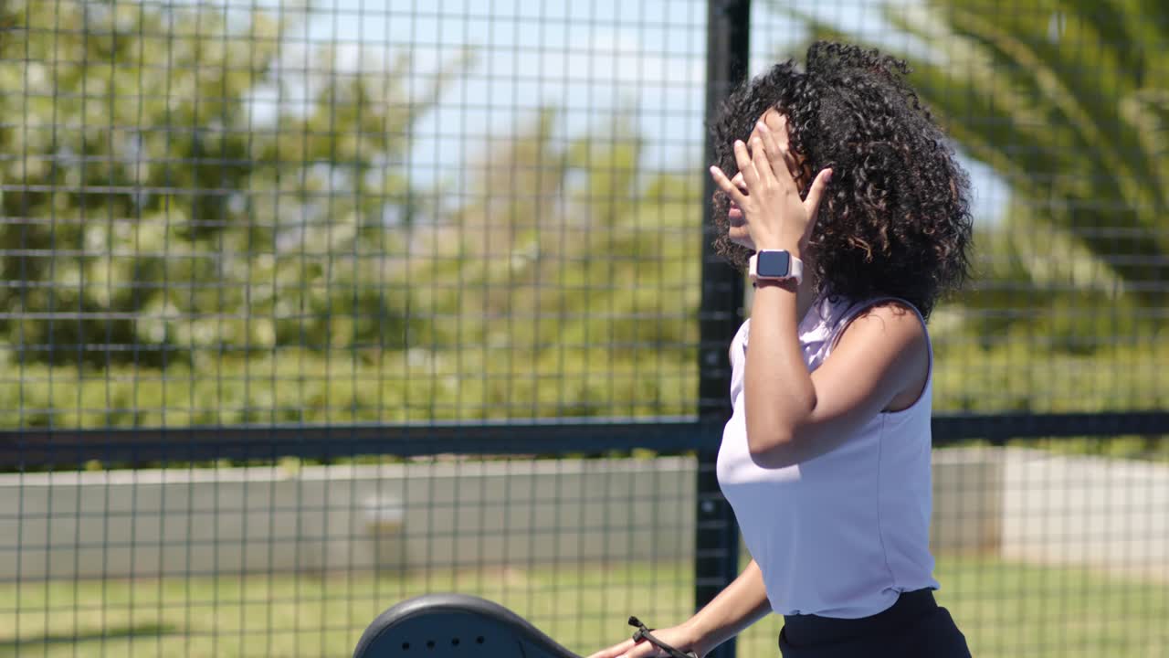 Adult female player in polo stepping tracking incoming ball swinging paddle returning on blue court
