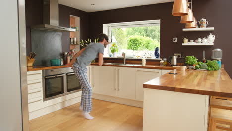 man playing a vr game in pajamas in the kitchen