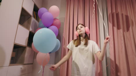 girl playing with balloons at birthday party