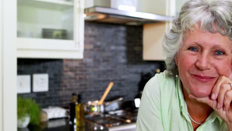 happy senior woman sitting in kitchen 4k