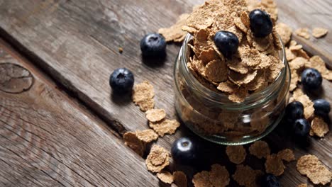 jar filled with wheat flakes and blueberries 4k