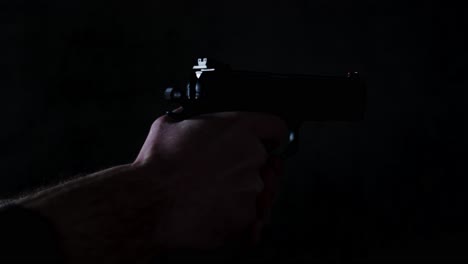 pistola de 9 mm disparando varias veces hasta que esté vacía en una habitación oscura