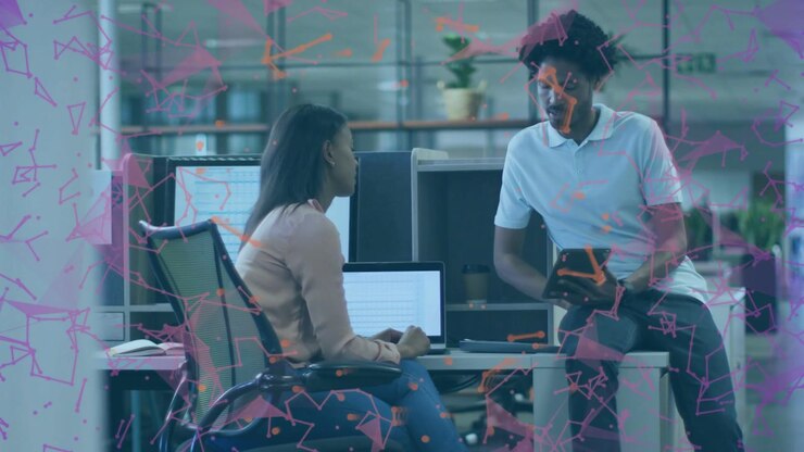 Man leaning on desk holding tablet, woman pointing at laptop, talking business under pink overlay