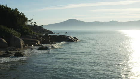 aerial view sunset waves crashing on rocks, fantastic rocky coast, jurere internacional, florianopolis, santa catarina, brazil