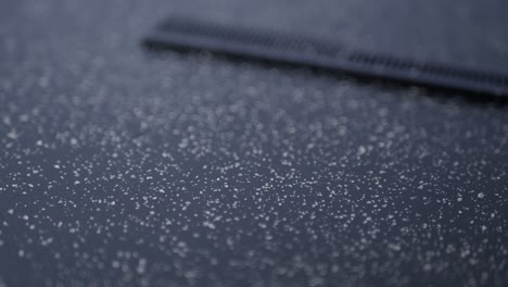 snow on a dark surface with a hair comb