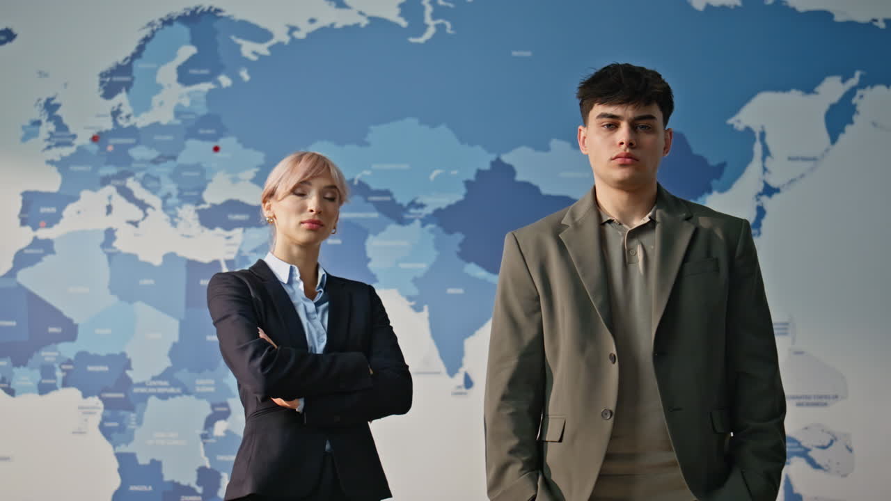 Global market specialists posing at blue world map background in office portrait