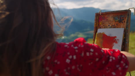 Girl-painter-drawing-meadow-close-up.-Woman-painting-using-easel-in-mountains.