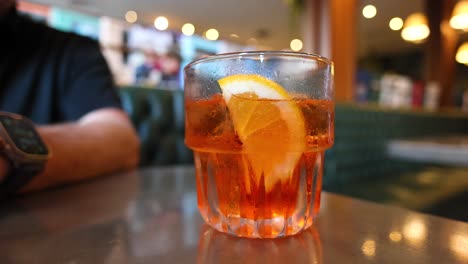 person drinking a beverage with orange slice